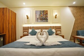 Una habitación de hotel con una cama, un armario de madera, un cuadro en la pared y una silla azul.