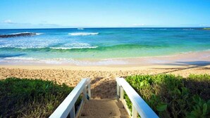 A beach with a wooden walkway leading to the shore, clear blue water, and a sandy beach. - Ground-Floor Retreat W/Ocean Views-Kiahuna 2166 (Koloa)