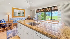 A modern kitchen with granite countertops, white cabinetry, and a large island. - Ground-Floor Retreat W/Ocean Views-Kiahuna 2166 (Koloa)