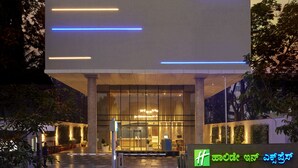 Een Holiday Inn Express gebouw met een modern design, met een opvallende ingang en verlichte signage.