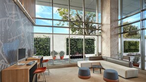 Een modern interieur met een groot raam, zithoek en een bureau met een computer.