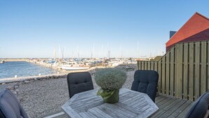 A wooden deck with a table and chairs overlooking a marina with boats. - "Line" - 10m from the sea by Interhome (Glesborg)