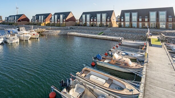 A marina with boats docked, a wooden pier, and modern buildings with large windows. - "Line" - 10m from the sea by Interhome (Glesborg)