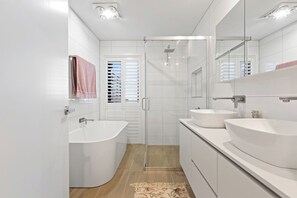 Bathtub, hair dryer, towels, shampoo