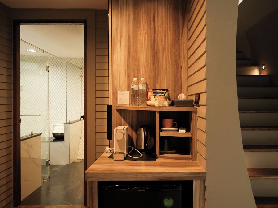 Eine moderne Küche mit Holzschnitzereien, einer Kaffeemaschine und einem Kühlschrank.