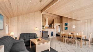 Un intérieur moderne avec un plafond en bois, un canapé, une table basse et un coin repas comprenant des chaises et une table.