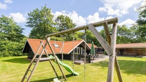 A wooden swing set in a grassy area with a building in the background. - "Sighrik" - 30km from the sea by Interhome (Toftlund)