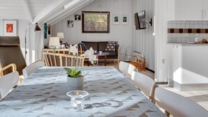 A modern, well-lit dining area with a geometric-patterned tablecloth, a central potted plant, and a clear glass candle holder. - "Sighrik" - 30km from the sea by Interhome (Toftlund)