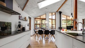 Een moderne keuken met een centraal eiland, grote ramen en een dakraam.
