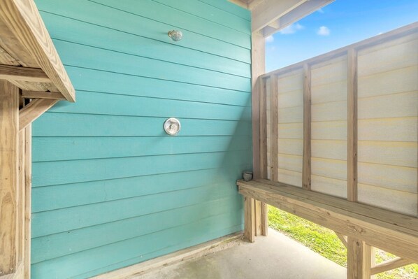 Paredes de madeira azul-turquesa com uma janela e uma porta.