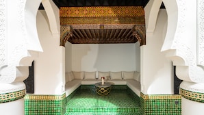 A Moroccan-style interior with a seating area, patterned tiles, and decorative arches. - The Grand Riad & Spa  (Marrakech)