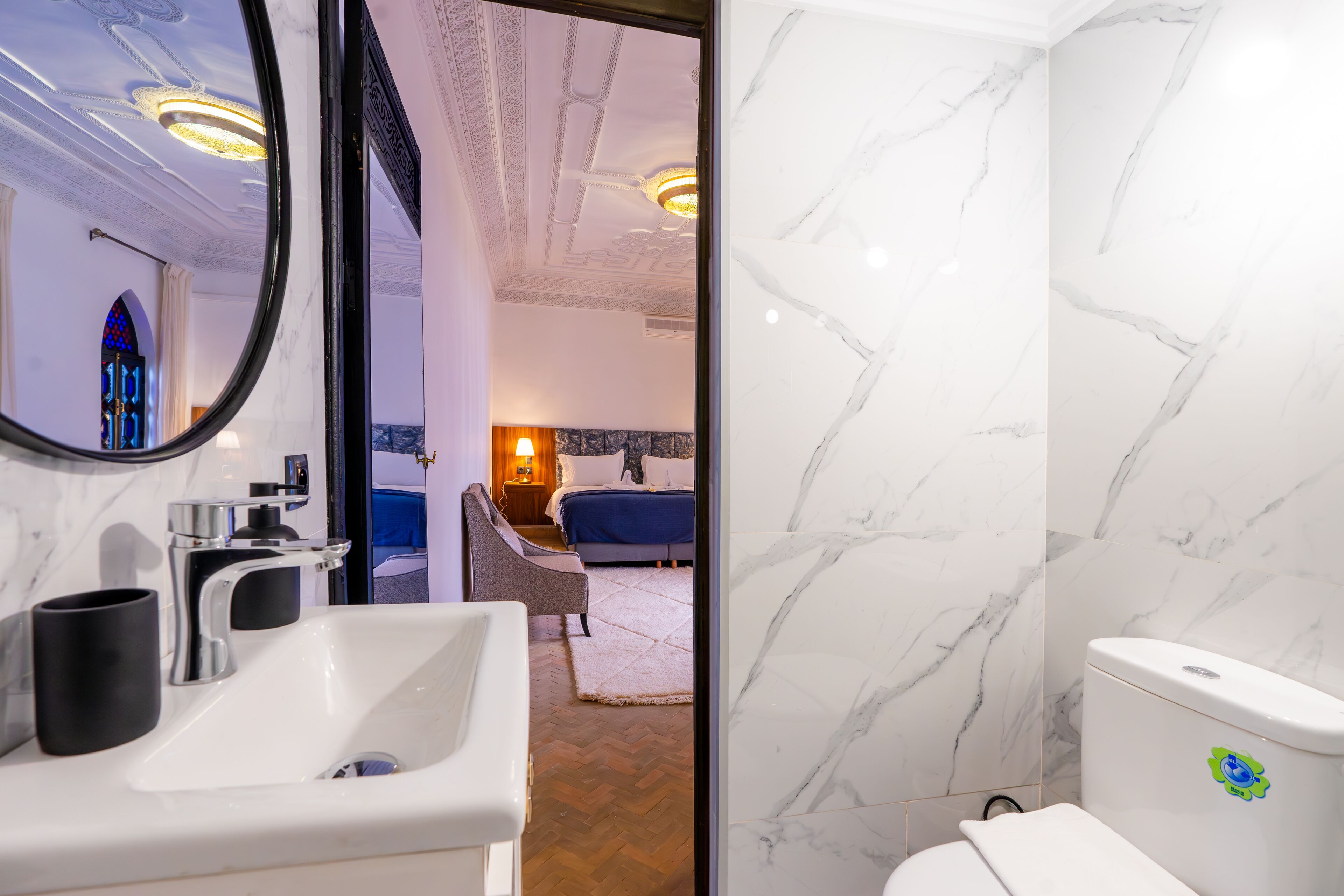 A modern bathroom with a white sink, a toilet, and a mirror.