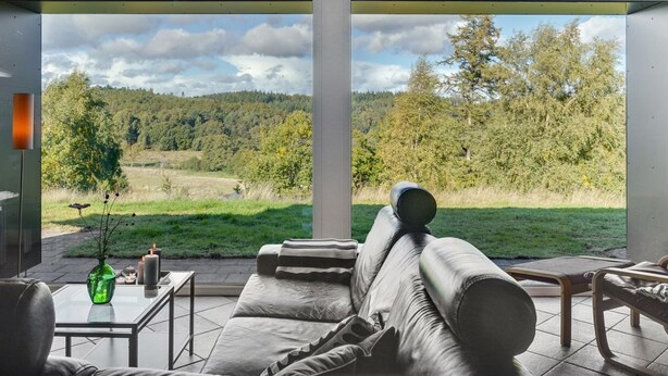 A modern living room with a large window, a sofa, a coffee table, and a vase. - "Merja" - 3km from the sea by Interhome (Ebeltoft)