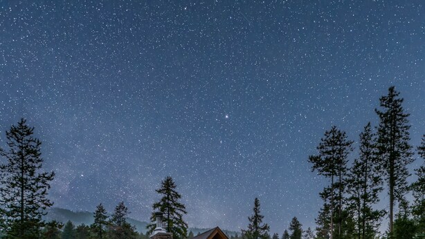 A lodge with a deck, stone fire pit, and outdoor seating. - Upscale 4BR mountain retreat with private hot tub, AC, and Mountain Club access. (Kimberley)