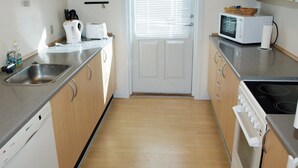 A compact kitchen with a Bosch dishwasher, a microwave, and a stove. - "Luise" - 800m from the sea by Interhome (Egernsund)