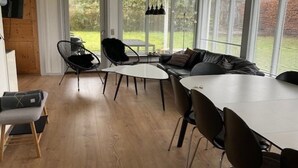 A modern interior with a dining area, a sofa, and large windows. - "Luise" - 800m from the sea by Interhome (Egernsund)