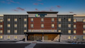 A multi-story hotel with a modern facade, featuring a prominent sign for "Woodspring Suites".