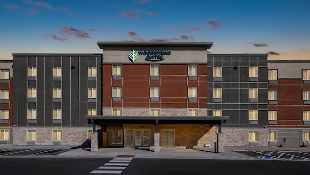 A multi-story hotel with a modern facade, featuring a prominent sign for "Woodspring Suites". - WoodSpring Suites Greeley (Greeley)