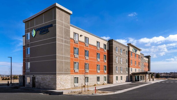 A multi-story hotel with a modern design, featuring a prominent logo on the facade.