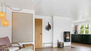 Ein modernes Wohnzimmer mit einer Couch, einem Esstisch und einer Küchenzeile mit Herd.
