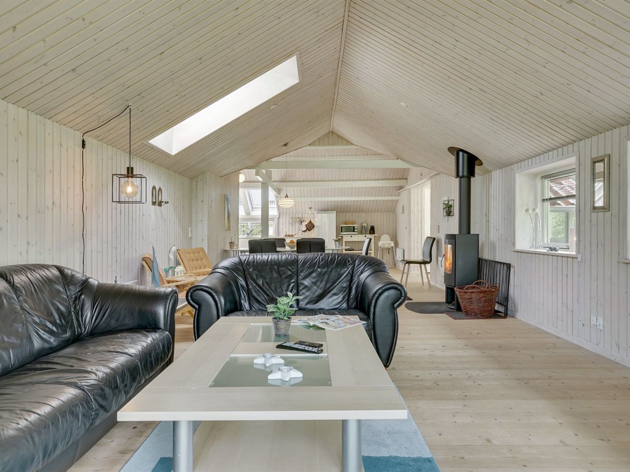 A spacious loft with a high ceiling, a central seating area with a coffee table, and a cozy fireplace.