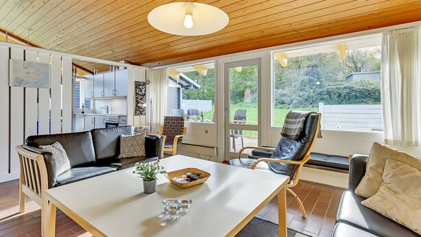 A cozy living area with a sofa, a dining table, and a kitchen in the background. - "Boris" - 500m from the sea by Interhome (Aabenraa)