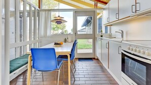 A modern kitchen with a dining area, featuring a wooden ceiling, large windows, and a built-in oven. - "Boris" - 500m from the sea by Interhome (Aabenraa)