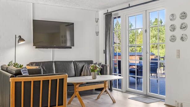 A modern living room with a sofa, a coffee table, and a TV mounted on the wall.