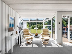 A sunlit room with two leather chairs, a small table, and a TV on the wall. - "Skakke" - 900m from the sea by Interhome (Blåvand)