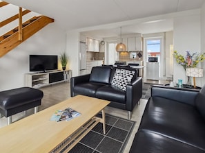 A modern living room with a sofa, a coffee table, and a TV.