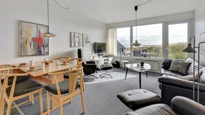 A modern living room with a dining area, large windows, and a view of the outdoors. - "Elizabeta" - 100m to the fjord by Interhome (Hvide Sande)