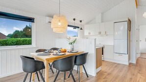 A modern kitchen with white cabinetry, a built-in oven, and a large window. - "Picabo" - 750m to the fjord by Interhome (Tarm)