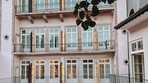 A multi-story building with balconies, a stone archway, and a well-maintained lawn. - GRANDE HOTEL PARIS by STAY HOTELS (Porto)
