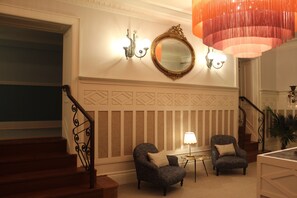 A staircase with a wooden handrail and a wall-mounted mirror above it. - GRANDE HOTEL PARIS by STAY HOTELS (Porto)