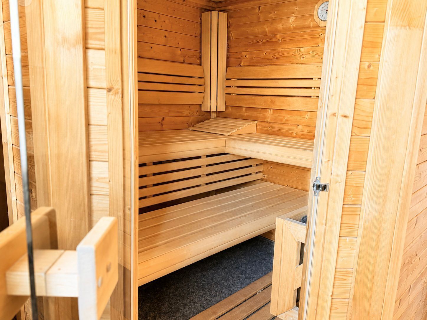Uma sauna de madeira com bancos e porta.