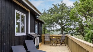 A deck with two lounge chairs, a table, and a chair.