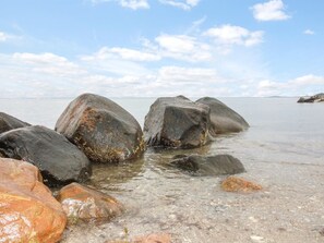 Eine felsige Küstenlinie mit großen Felsen und klarem Wasser.