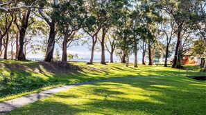 A park with a paved path, grassy areas, and trees.