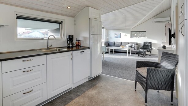 A modern kitchen with white cabinets, a black countertop, and a window above the sink. - "Ingward" - 300m to the fjord by Interhome (Tarm)