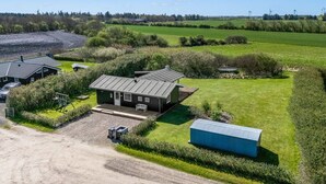 Une propriété rurale comprenant une maison principale, un bâtiment plus petit et un grand champ.