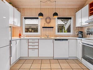 A modern kitchen with white cabinets, a dishwasher, and a stove. - "Jensen" - 700m to the fjord by Interhome (Oksbøl)