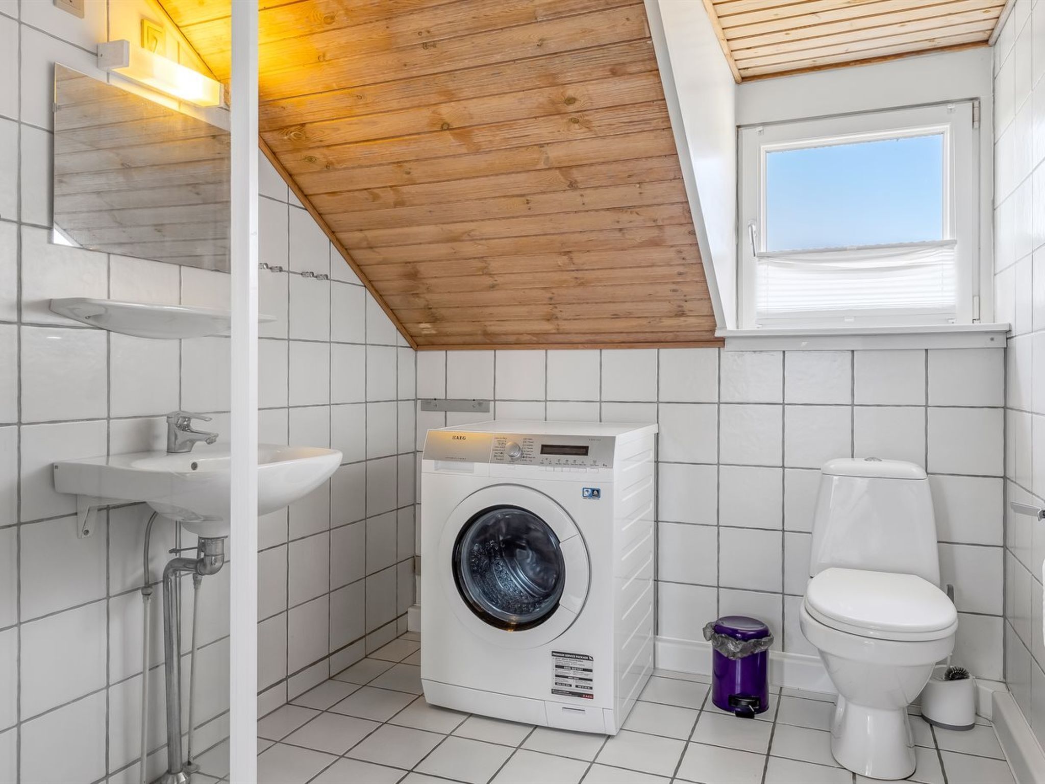 Kompakti ja moderni kylpyhuone, jossa on sisäänrakennettu pesukone, wc ja pesuallas.
