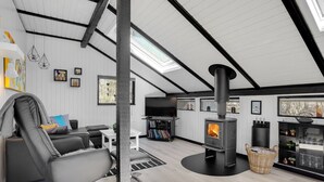 A modern living room with a black wood-burning stove, a comfortable gray sofa, a flat-screen TV, and a bookshelf. - "Elisabeta" - 28km from the sea by Interhome (Toftlund)