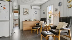 Eine moderne Küche mit Kühlschrank, Holzschrank und Essbereich mit Tisch und Stühlen.