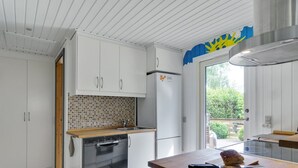 Une cuisine moderne avec des meubles blancs, un dosseret carrelé et un lave-vaisselle encastré.