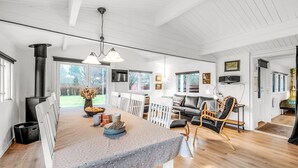 A spacious living room with a large wooden table, a fireplace, and a cozy seating area. - "Staffan" - 200m to the fjord by Interhome (Skjern)