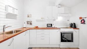 A modern kitchen with white cabinetry, a wooden countertop, a built-in oven, and a microwave. - "Staffan" - 200m to the fjord by Interhome (Skjern)