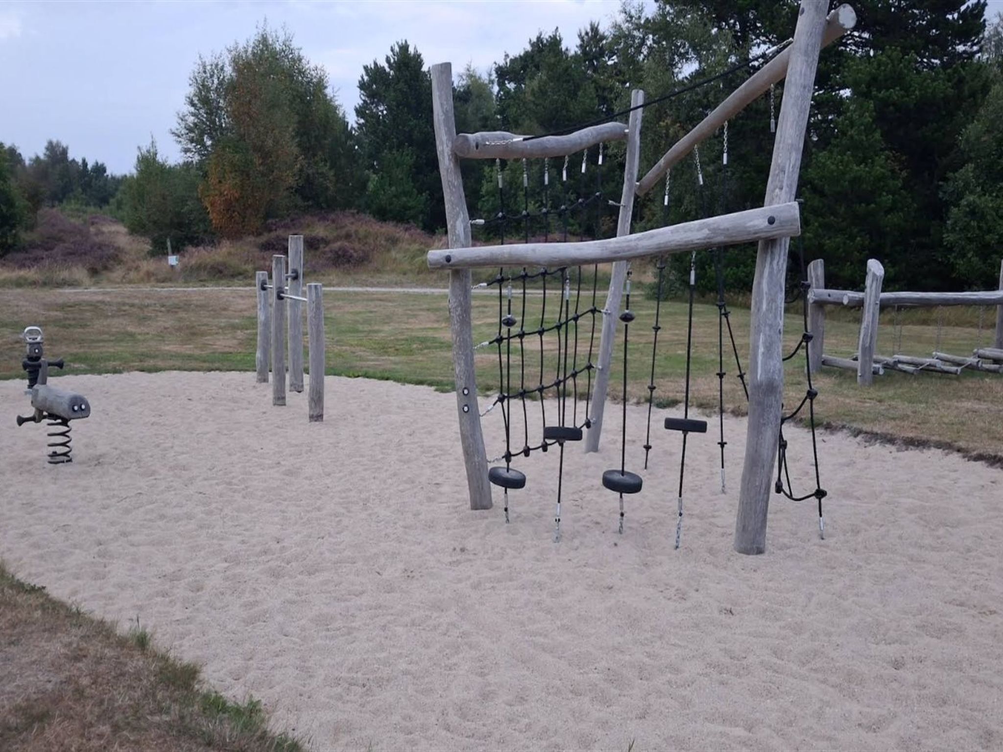 A playground with swings, a slide, and a climbing structure.