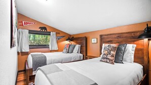 A bedroom with two beds, a window with curtains, a bear decoration, and a wooden headboard. - Saddle n' Sage, 7 min to Glacier, Fire Pit (Coram)