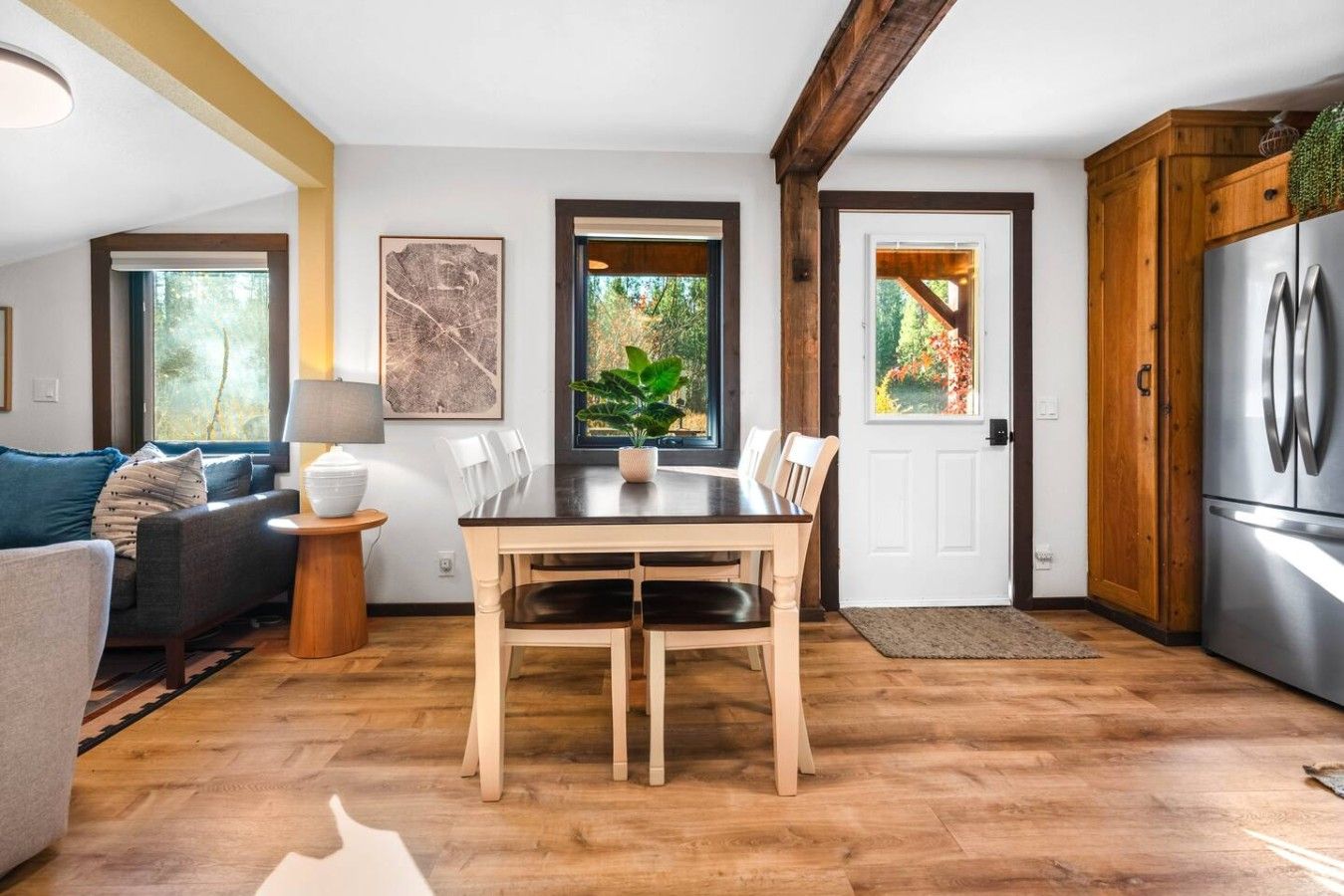Eine moderne Küche mit Essbereich, Holzboden und einem großen Kühlschrank.